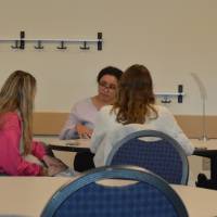 A photo of an alumna talking to two students at the 30 Minute Mentors Event